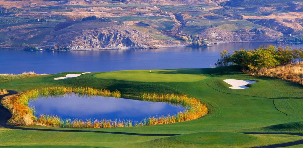 A golf hole surround by a pond and a river at Bear Mountain Ranch