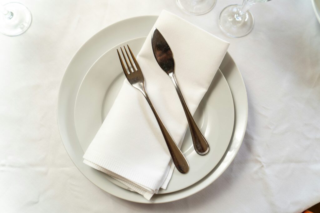A fork, knife, and napkin on top of two white plates